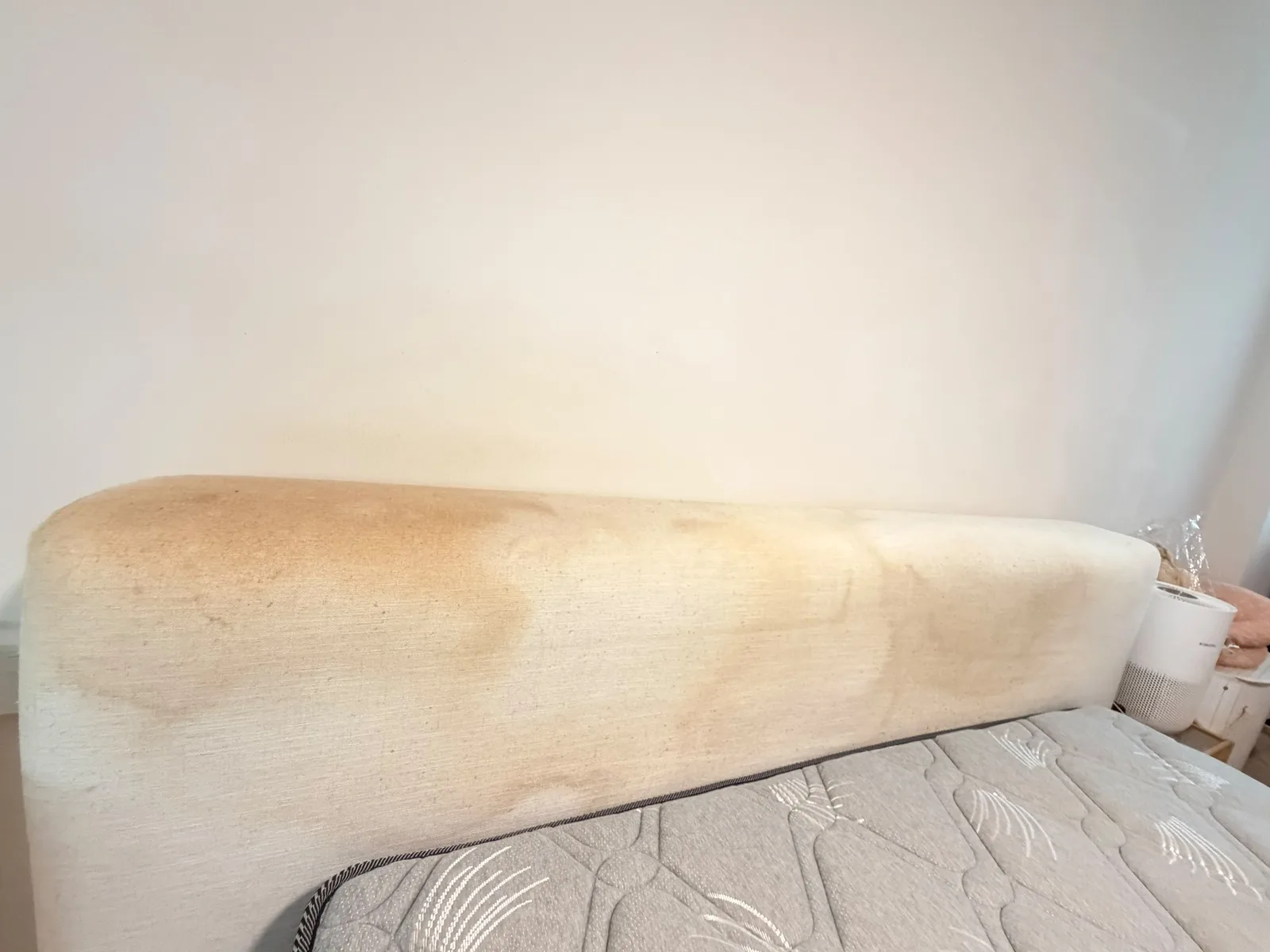 Upholstered headboard before cleaning โ visible staining and discolouration
