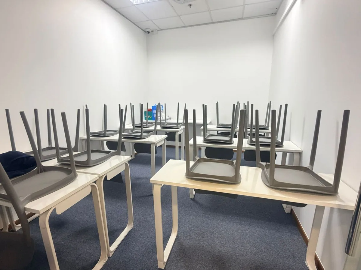 Chairs stacked for deep floor access — thorough office clean prep