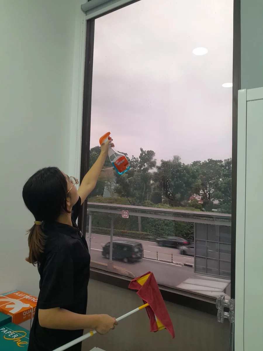 Office window cleaning — spraying and wiping glass panels